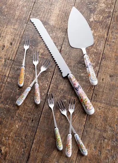 The Aynsley Pastry Set including a knife, six forks and a cake knife rest on to of a wooden tabletop